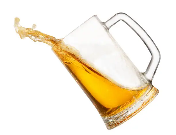 splashing beer in mug isolated on white background. Beer splash