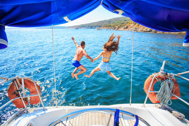 istock Rear view of couple jumping into ater 692546486