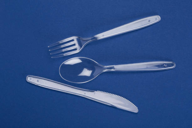 istock Transparent plastic cutlery set. Knife, fork, spoon on blue paper background 692553170