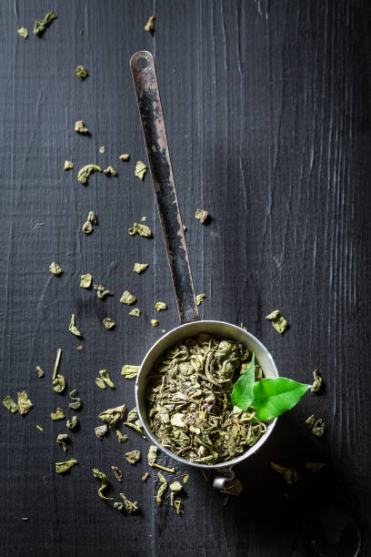istock Aromatic green tea on black wooden table 692557650