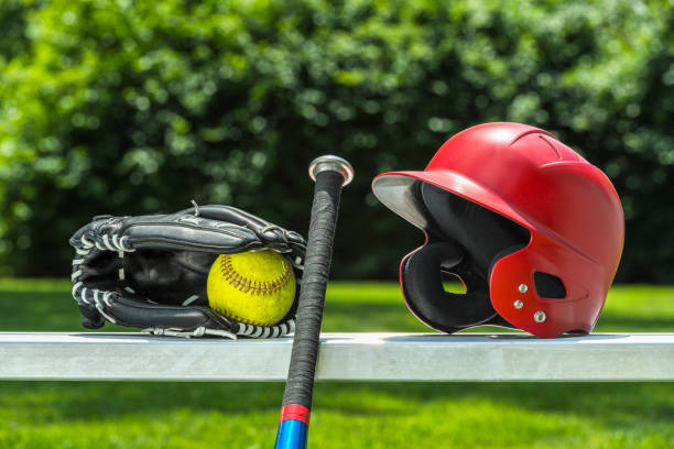 softball amarelo na luva com bastão e o capacete no banco - softball playing field fluorescent team sport - fotografias e filmes do acervo
