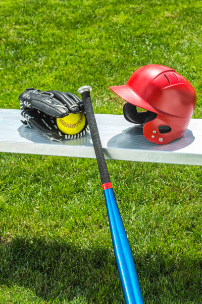 softball amarelo na luva com bastão e o capacete no banco - softball playing field fluorescent team sport - fotografias e filmes do acervo