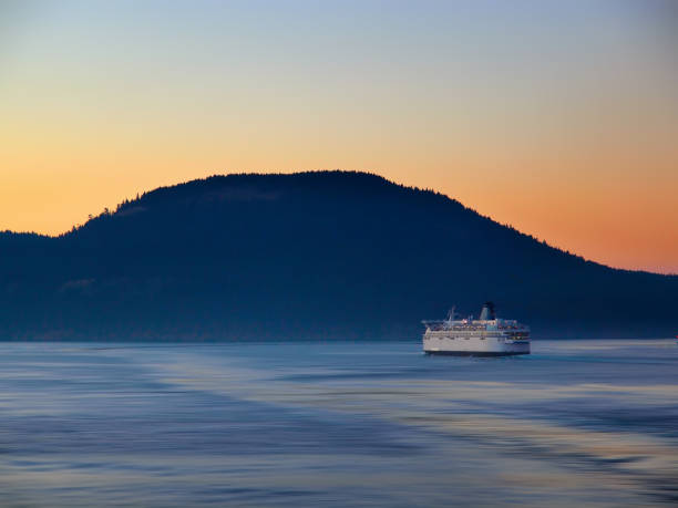 istock Ferry making its way by the island at the sunset time 692560928