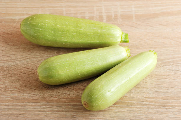 istock three young green zucchini on wooden background 692564182