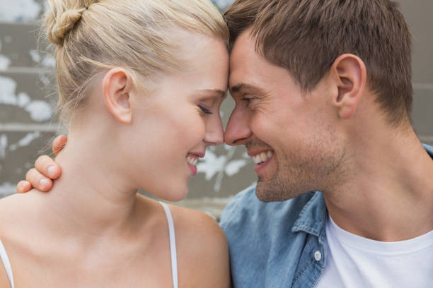 istock Hip young couple sitting on steps smiling at each other 692567434