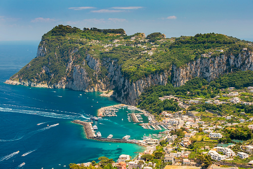 aerial view of italian holiday island Capri with picturesque marina and Tyrrhenian sea in background, Capri island, Campania region, Italy