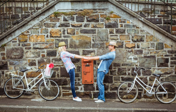 istock Hip young couple dancing by brick wall with their bikes 692573774