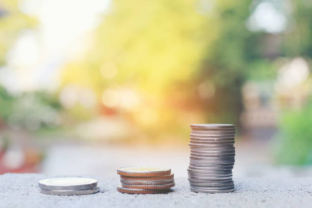 pila de monedas en el piso de cemento sobre la imagen borrosa de fondo abstracto de naturaleza verde con filtro de tono vintage, ahorrar dinero para el crecimiento de su negocio, el negocio y el concepto de finanzas - human hand beak currency stack fotografías e imágenes de stock