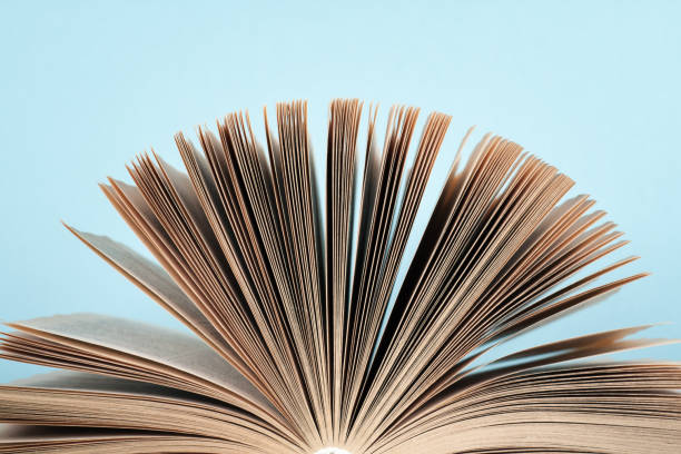 istock Book stacking. Open book, hardback books on wooden table and blue background. Back to school. Copy space for text 692581268