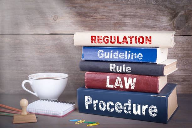 istock Regulation concept. Stack of books on wooden desk 692581322