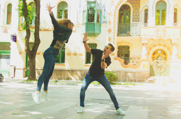 istock Young couple jumping in street 692598548