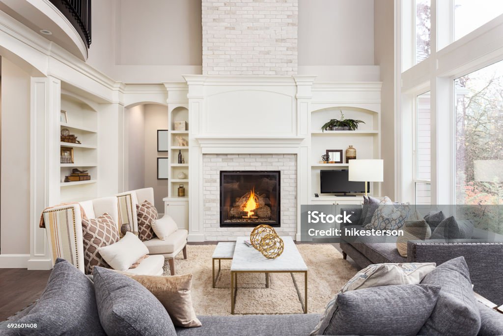 Beautiful living room interior with tall vaulted ceiling, loft area, hardwood floors and fireplace in new luxury home. Has large bank of windows living room in newly constructed luxury home Living Room Stock Photo