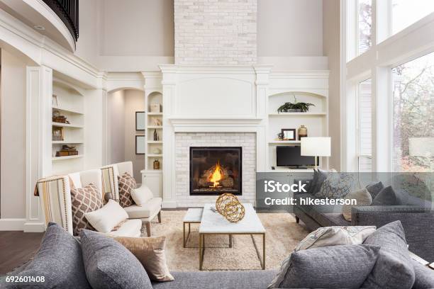 Beautiful Living Room Interior With Tall Vaulted Ceiling Loft Area Hardwood Floors And Fireplace In New Luxury Home Has Large Bank Of Windows Stock Photo - Download Image Now