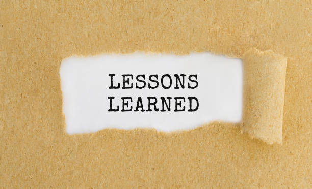 istock Text LESSONS LEARNED appearing behind ripped brown paper 692607836