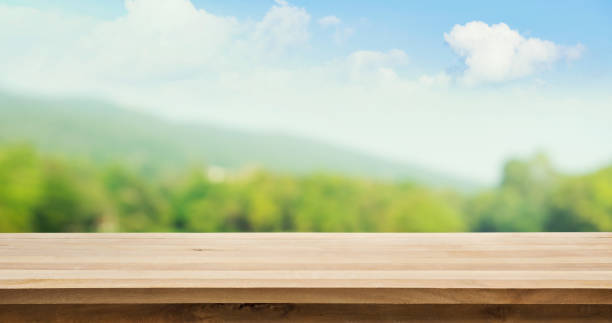 istock Wood table top on blur tree and mountain background 692609796