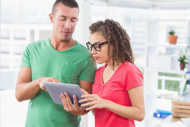 kreatywni koledzy biznesowi trzymający tablet - digital tablet young men women short hair zdjęcia i obrazy z banku zdjęć