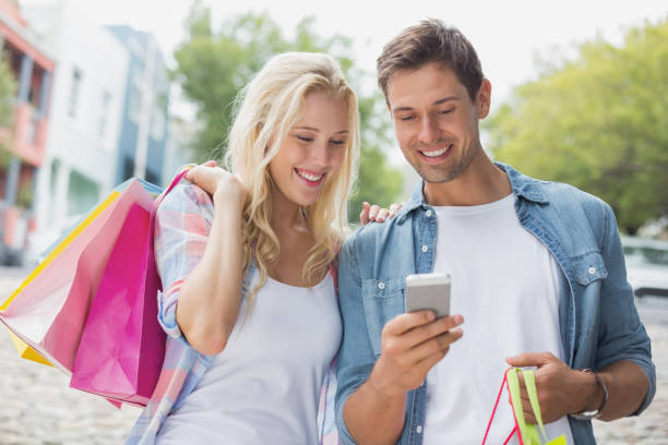 istock Hip young couple looking at smartphone on shopping trip 692618986