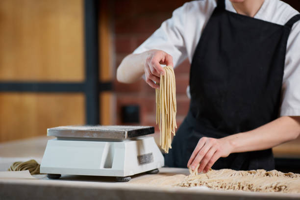 istock Woman scaling noodles in cafe 692621976
