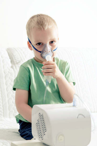 istock Boy making inhalation with nebulizer at home 692622312