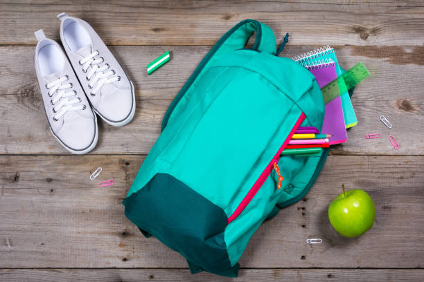 istock Backpack with school stationery on wooden background 692626898