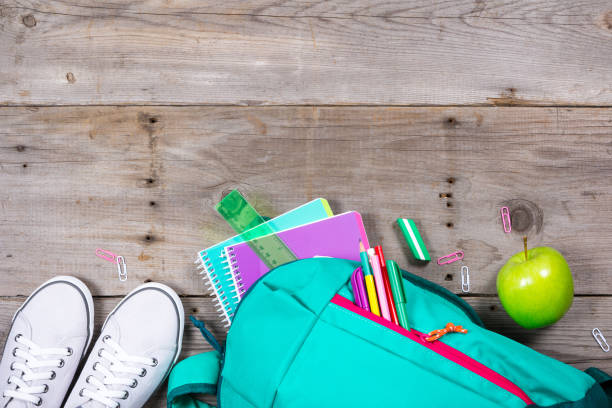 istock Backpack with school stationery on wooden background 692627604