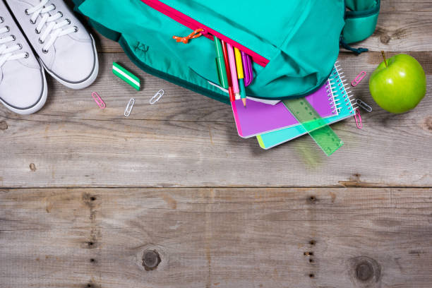 istock Backpack with school stationery on wooden background 692627666