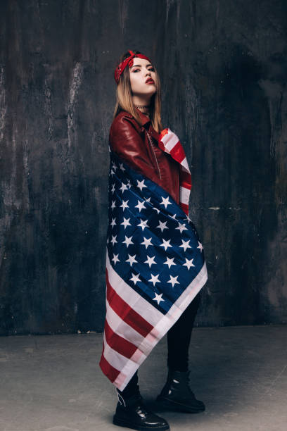 istock Girl covered by american flag on dark background 692627906