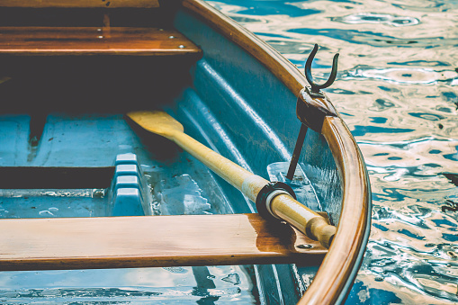 Close up of an wooden pleasure rowboat at the pier of a lake