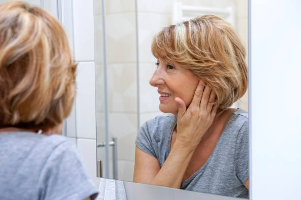 istock Mature woman examining her face in the mirror 692632204