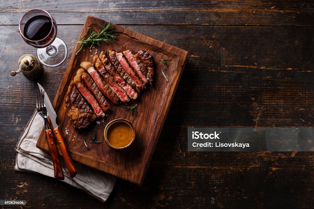 Grilled sliced Steak Rib eye with Pepper sauce Grilled sliced Steak Rib eye with Pepper sauce and Red wine on wooden background copy space Steak Stock Photo