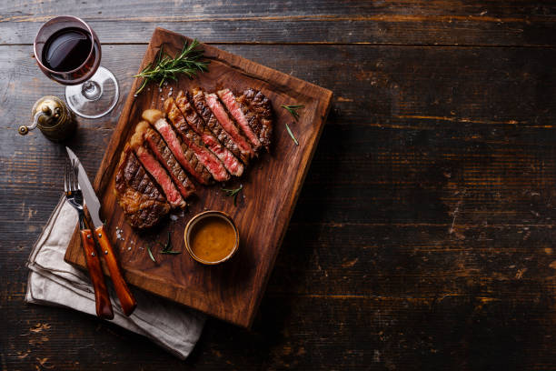 Grilled sliced Steak Rib eye with Pepper sauce Grilled sliced Steak Rib eye with Pepper sauce and Red wine on wooden background copy space steak stock pictures, royalty-free photos & images