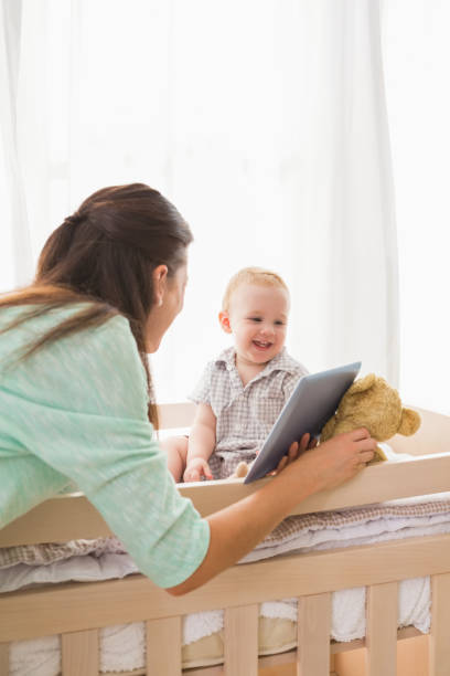 istock Happy mother using tablet with his baby boy 692634988