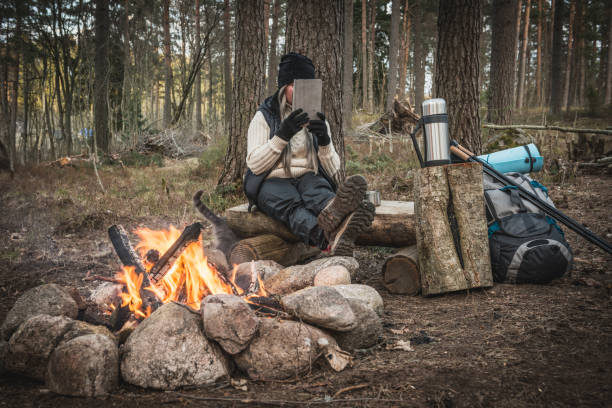 istock A woman resting by the campfire and drinking a hot drink 692635114