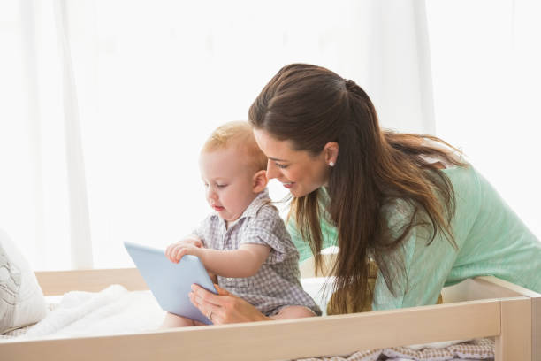 istock Happy mother using tablet with his baby boy 692635150