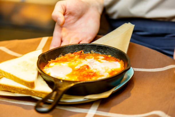 istock Cast iron black frying pan with scrambled eggs with tomatoes. A restaurant that guests don't see. 692638506