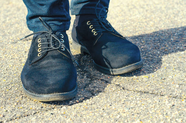 istock Old Black Female Shoes with Asphalt Background 692644684