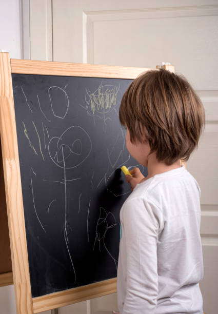 istock Little Boy Drawing With Chalk On Blackboard 692651754