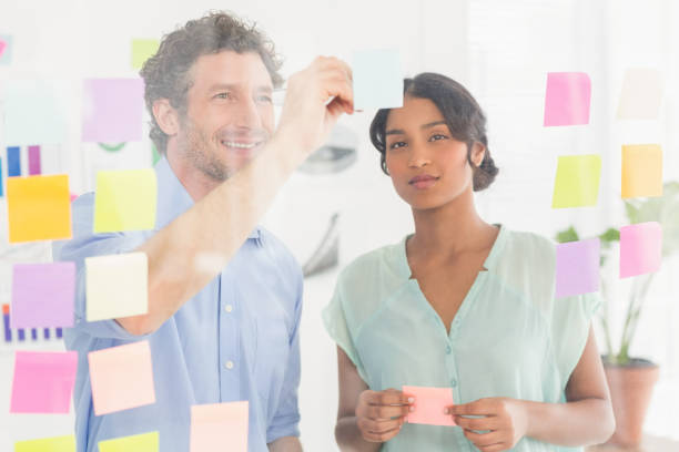 istock Puzzled business team looking post its on the wall 692655012