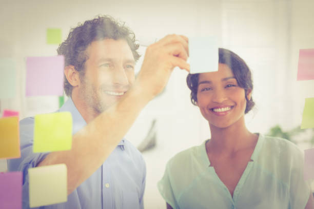 istock Puzzled business team looking post its on the wall 692655076