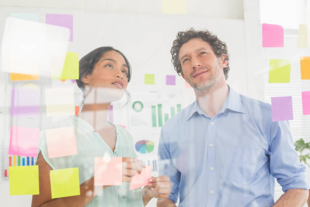 istock Puzzled business team looking post its on the wall 692655122