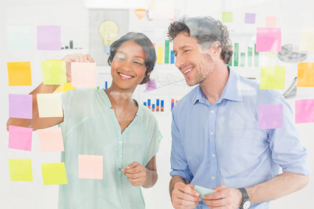 istock Puzzled business team looking post its on the wall 692655256