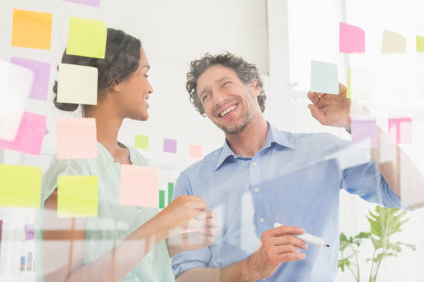 istock Puzzled business team looking post its on the wall 692657298