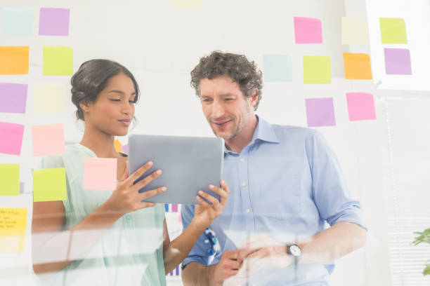 istock Puzzled business team looking post its on the wall 692657458
