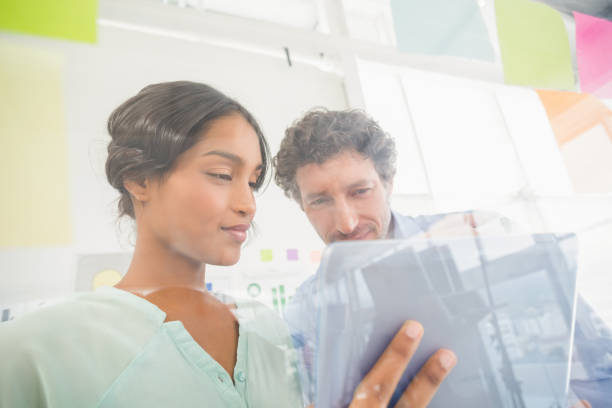 istock Puzzled business team looking post its on the wall 692657586