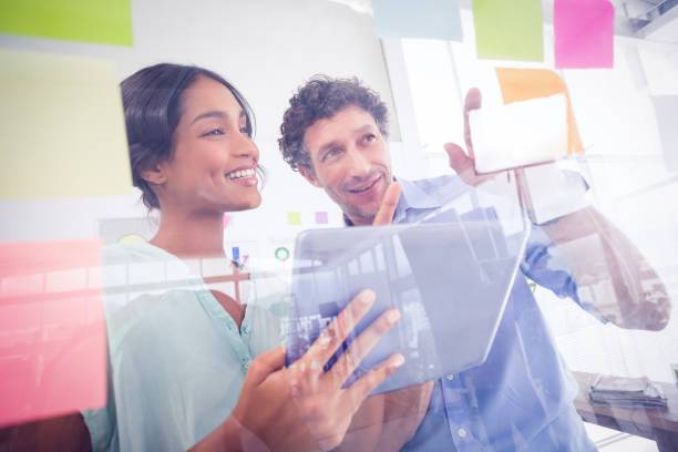 istock Puzzled business team looking post its on the wall 692657674