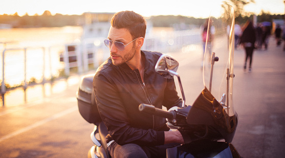 Handsome man sitting on the motorbike and resting