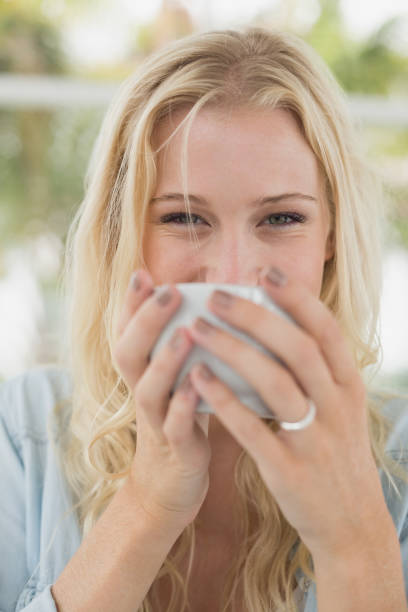 istock Pretty blonde sitting at table having coffee smiling at camera 692661374