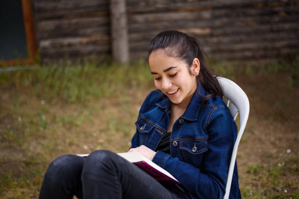 istock Teenage girl reading a book 692661470