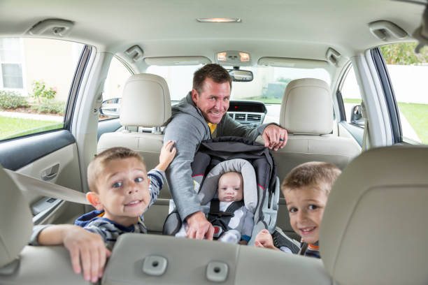 istock Father in car with baby and two boys 692664482