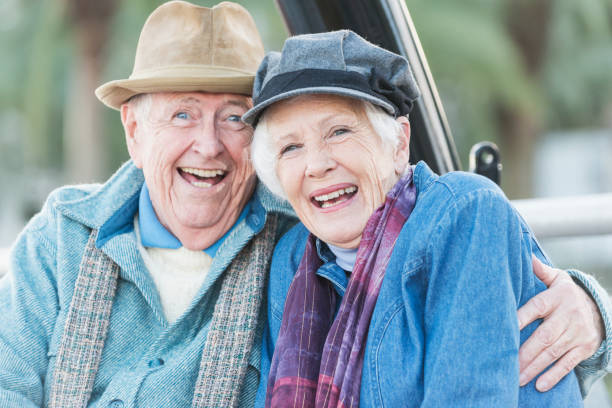 istock Old couple sitting outdoors together, laughing 692670388